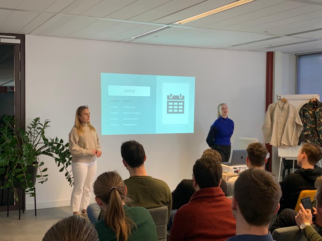 Two students presenting their venture timeline to a full room at the Amsterdam campus