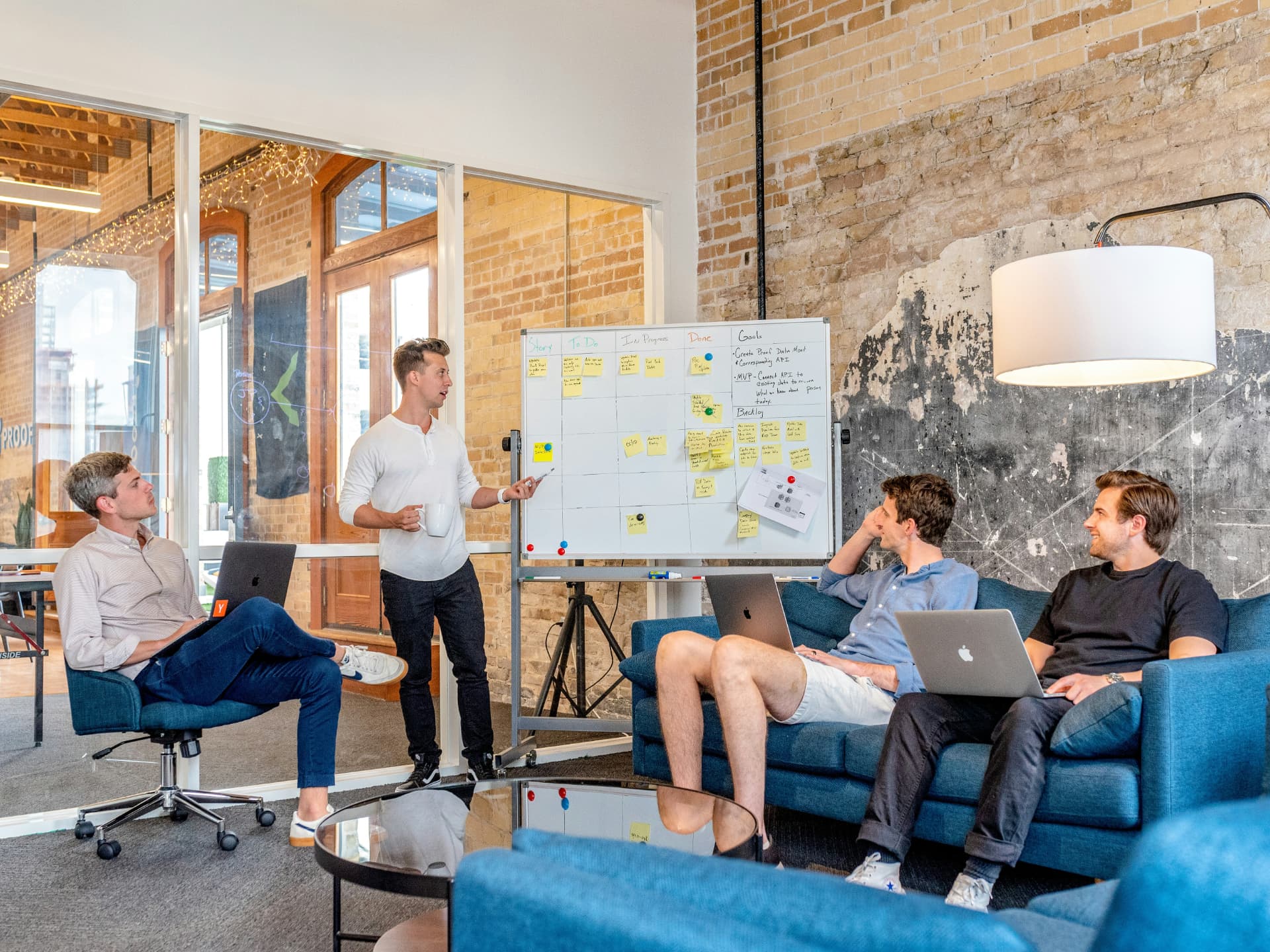 Entrepreneurial team collaborating around a whiteboard with sticky notes during a sprint session